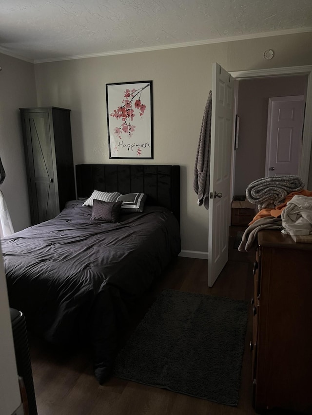 bedroom with dark hardwood / wood-style flooring and ornamental molding