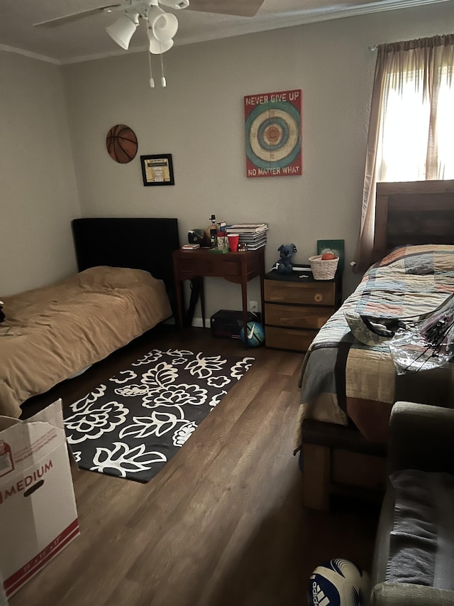 bedroom with hardwood / wood-style flooring, ceiling fan, and crown molding