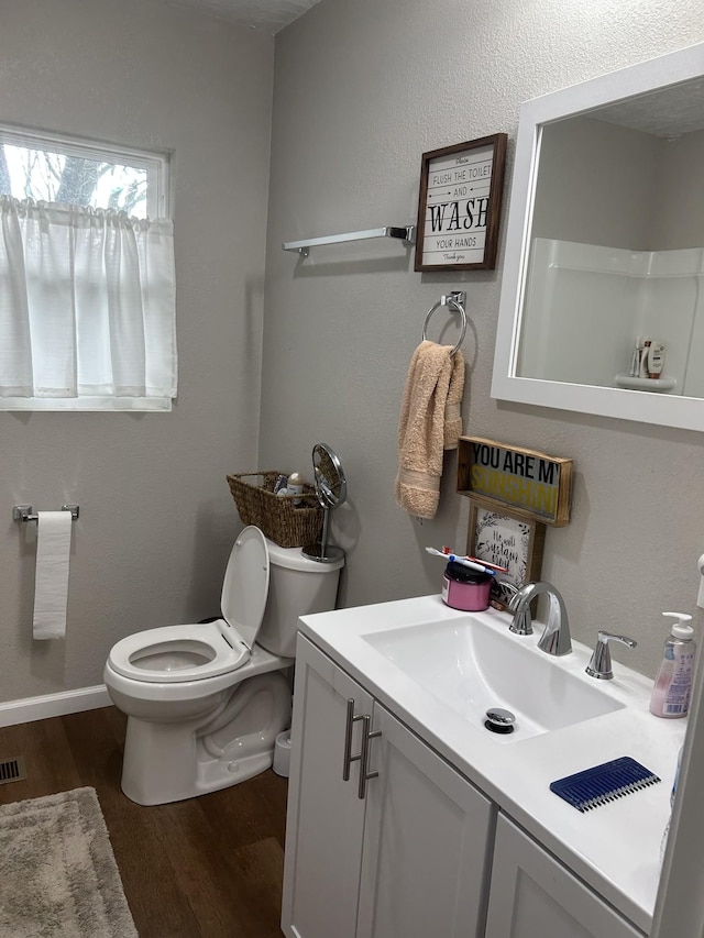 bathroom with vanity, wood-type flooring, and toilet