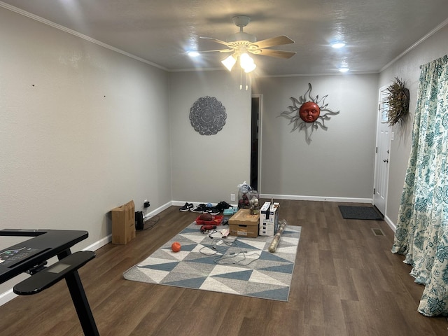 interior space featuring ceiling fan, ornamental molding, and dark wood-type flooring