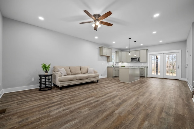 living room with ceiling fan, dark hardwood / wood-style flooring, and sink