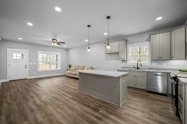 kitchen with appliances with stainless steel finishes, decorative light fixtures, a kitchen island, and gray cabinetry