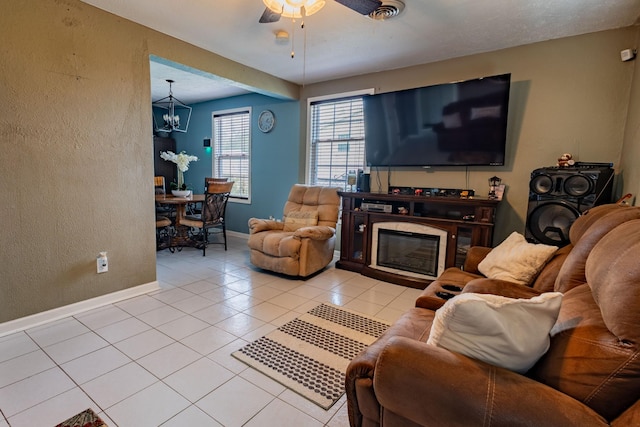 tiled living room featuring ceiling fan with notable chandelier