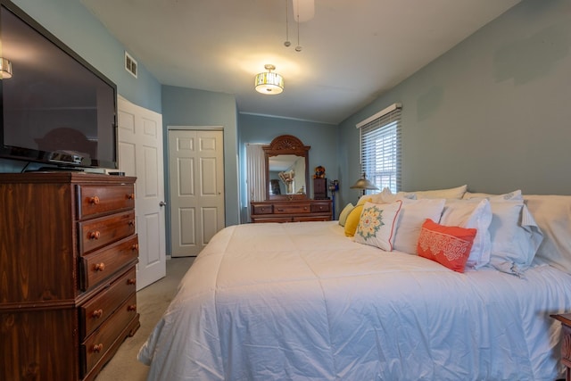 carpeted bedroom featuring ceiling fan and a closet