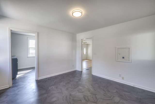 unfurnished room featuring dark parquet flooring and electric panel