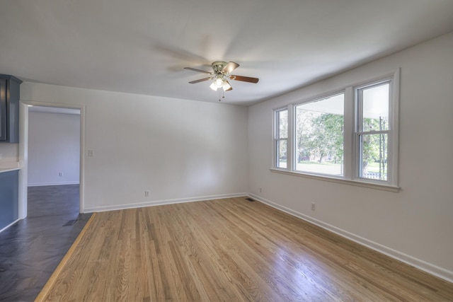 unfurnished room with dark hardwood / wood-style floors and ceiling fan