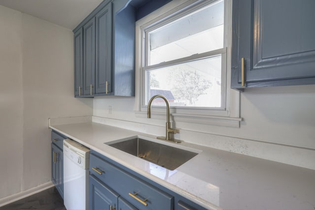 kitchen with dishwasher, blue cabinets, and sink