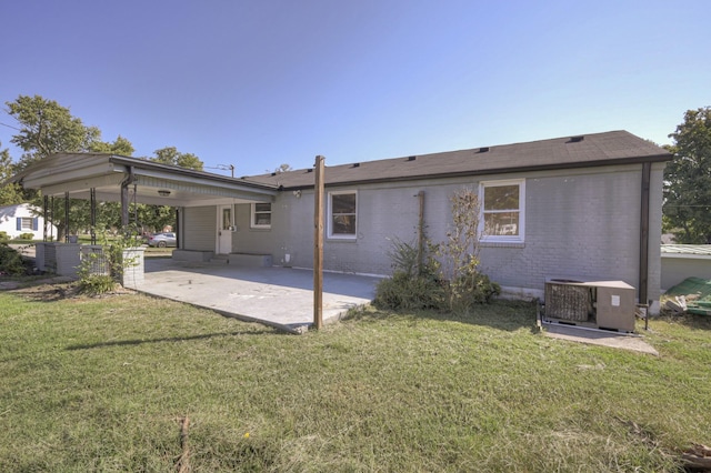 back of property with a patio, central AC unit, and a lawn