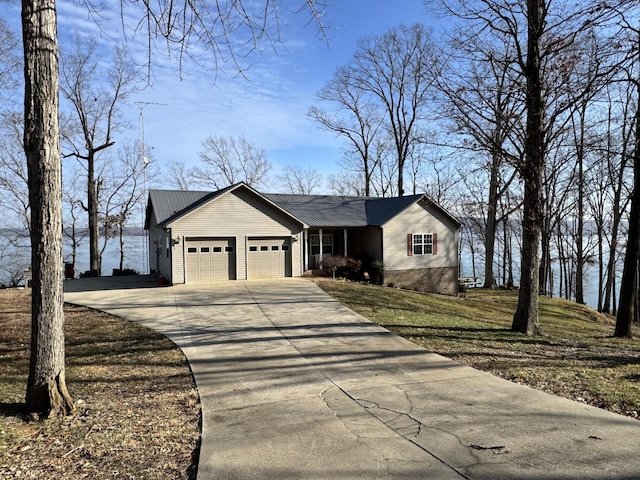 view of front of property with a water view, a garage, and a front lawn