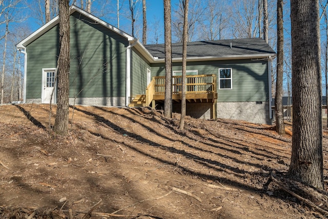 back of house with crawl space and a deck