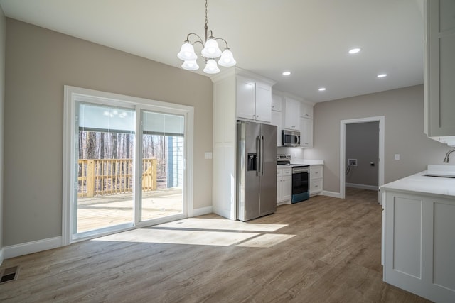 kitchen featuring light wood finished floors, light countertops, recessed lighting, appliances with stainless steel finishes, and white cabinets