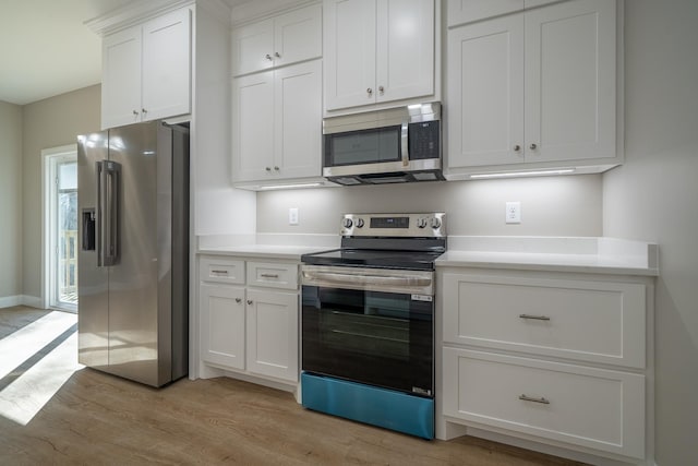 kitchen featuring light wood finished floors, white cabinets, appliances with stainless steel finishes, and light countertops