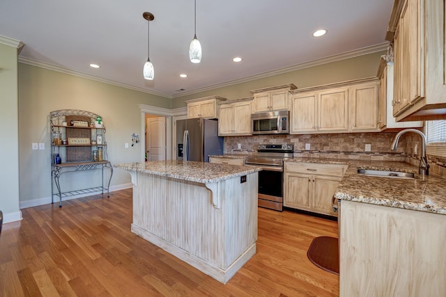 kitchen featuring appliances with stainless steel finishes, light stone counters, a kitchen island, and sink