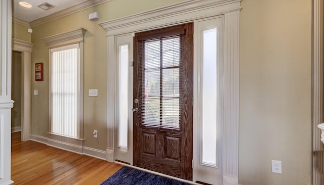 doorway featuring crown molding and light hardwood / wood-style floors