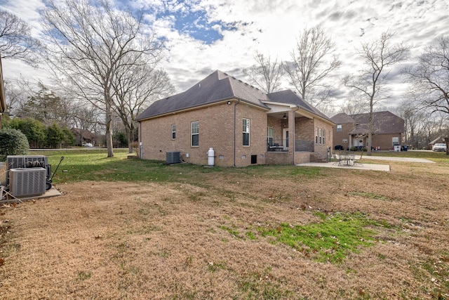 view of side of property featuring a patio, cooling unit, and a lawn