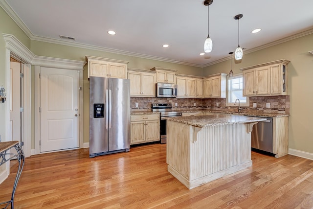 kitchen featuring a kitchen breakfast bar, light stone counters, stainless steel appliances, decorative light fixtures, and a center island