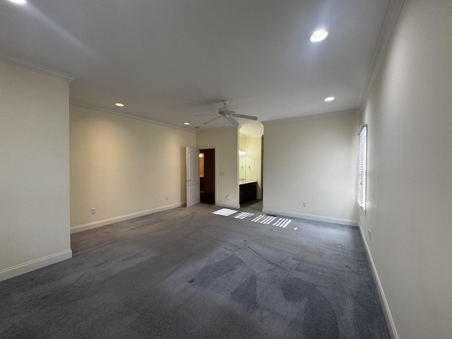 unfurnished room featuring ceiling fan, dark carpet, and crown molding