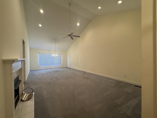 unfurnished living room with ceiling fan with notable chandelier, light colored carpet, and high vaulted ceiling