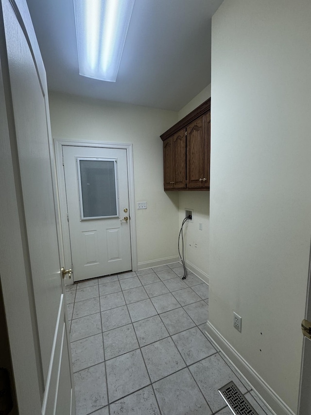 laundry area with light tile patterned flooring, cabinets, and hookup for a washing machine