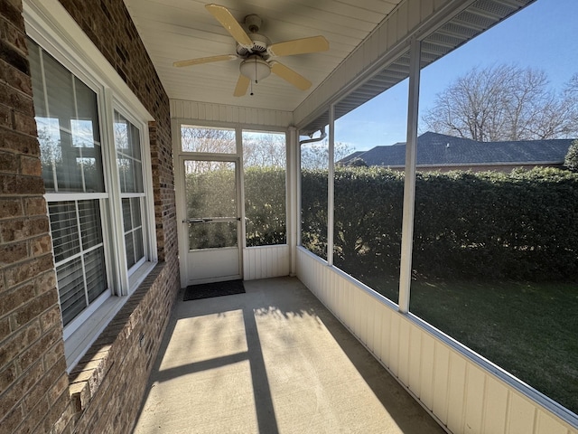 unfurnished sunroom featuring a mountain view and ceiling fan