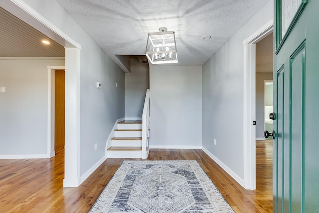 interior space with an inviting chandelier, wood-type flooring, and a textured ceiling