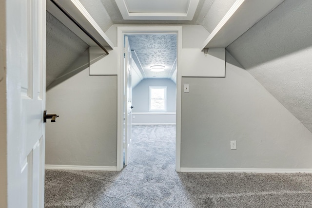 bonus room featuring lofted ceiling, carpet floors, and a textured ceiling