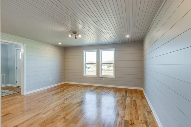 unfurnished room with wooden ceiling and light wood-type flooring