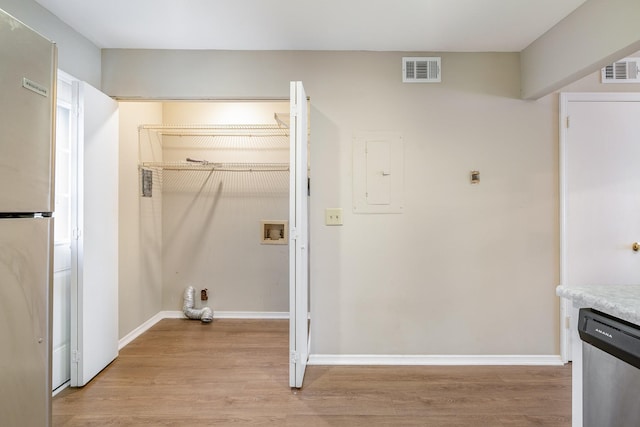 laundry room with hookup for a washing machine, electric panel, and light hardwood / wood-style flooring