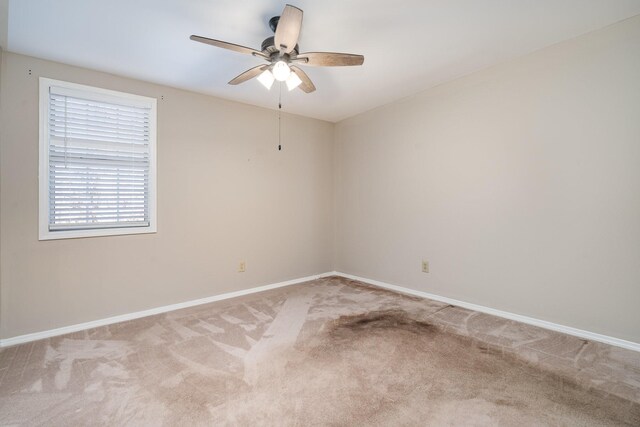 empty room featuring light colored carpet and ceiling fan