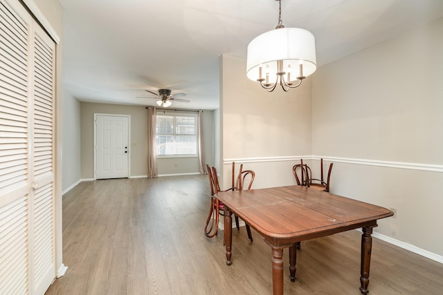 dining room with ceiling fan with notable chandelier and hardwood / wood-style floors