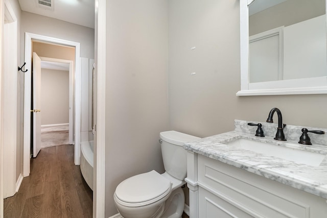 bathroom featuring vanity, wood-type flooring, and toilet