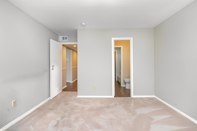 unfurnished bedroom with carpet and connected bathroom