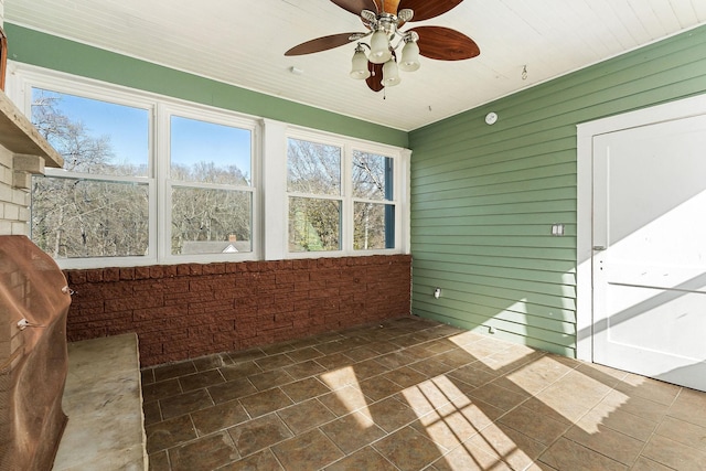 unfurnished sunroom featuring ceiling fan and wooden ceiling