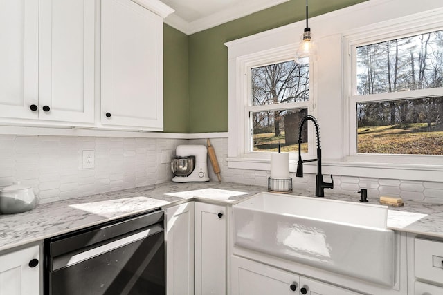 kitchen with white cabinetry, ornamental molding, sink, and light stone counters