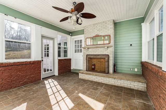 unfurnished sunroom featuring ceiling fan and wooden ceiling