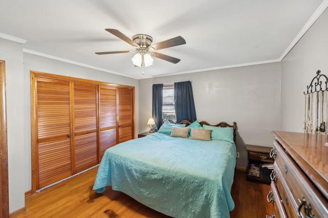 bedroom with ceiling fan, a closet, crown molding, and hardwood / wood-style flooring