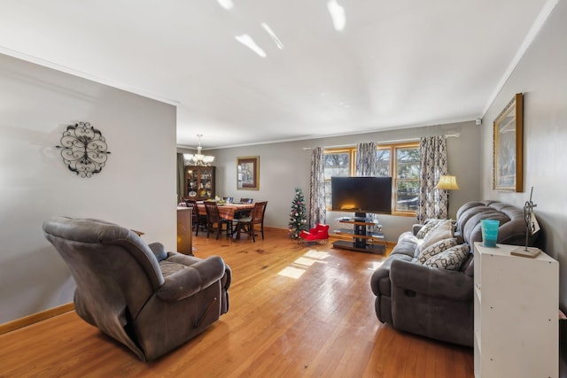 living room featuring an inviting chandelier, wood-type flooring, and ornamental molding