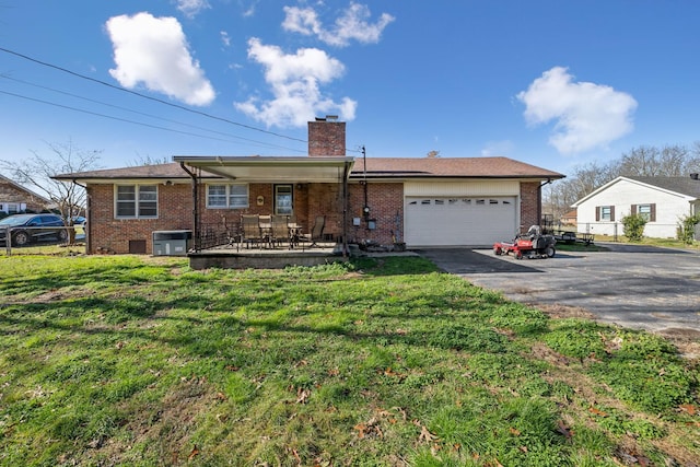 ranch-style home featuring central AC unit, a garage, and a front lawn