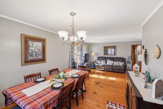 dining space featuring a notable chandelier, light hardwood / wood-style floors, and crown molding