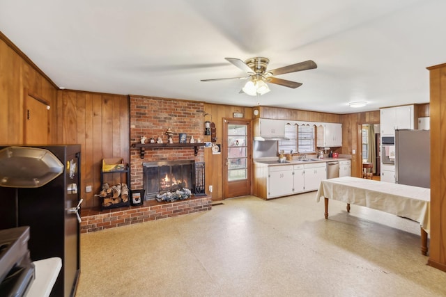 living room with ceiling fan, billiards, a fireplace, and wooden walls