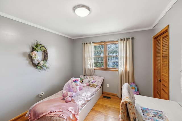 bedroom featuring light hardwood / wood-style floors and crown molding