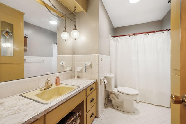 bathroom featuring vanity, toilet, and tile walls