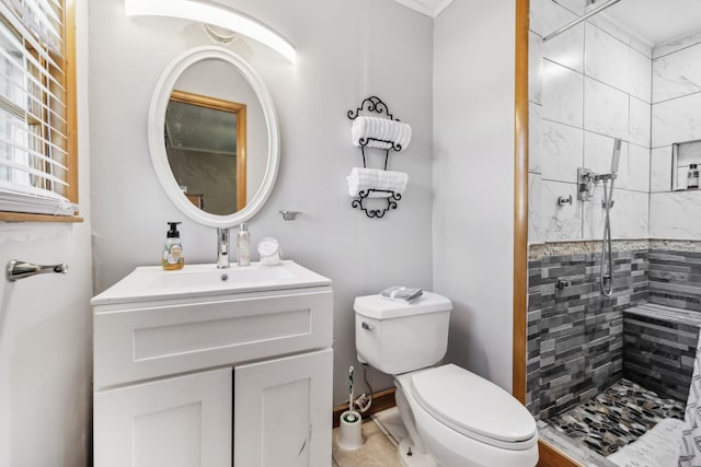 bathroom featuring tiled shower, vanity, and toilet