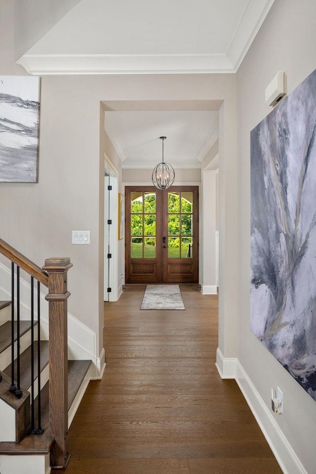 foyer entrance featuring ornamental molding, french doors, wood-type flooring, and a notable chandelier