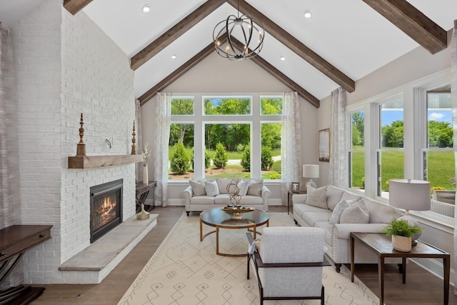 living room featuring high vaulted ceiling, an inviting chandelier, light hardwood / wood-style floors, a fireplace, and beam ceiling