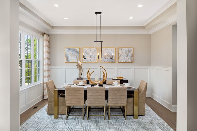 dining space featuring ornamental molding, light hardwood / wood-style flooring, and an inviting chandelier