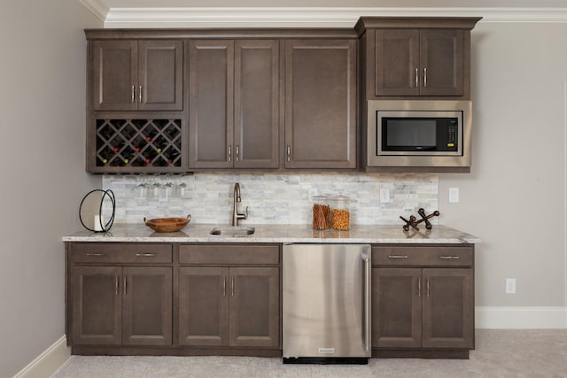 bar featuring stainless steel microwave, refrigerator, dark brown cabinets, and sink