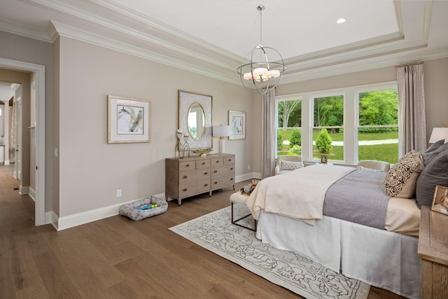 bedroom with a chandelier, dark hardwood / wood-style floors, a raised ceiling, and crown molding