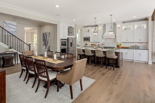 dining space with light hardwood / wood-style floors and ornamental molding