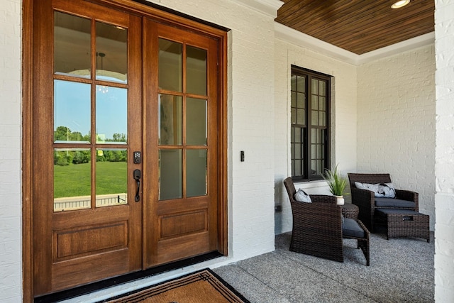 property entrance featuring covered porch and french doors